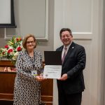 alumna posing with president brien lewis