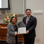 alumna posing with president brien lewis