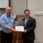 alumnus posing with president brien lewis