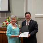 alumna posing with president brien lewis