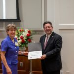 alumna posing with president brien lewis