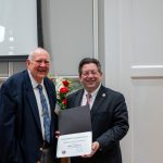 alumnus posing with president brien lewis