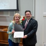 alumna posing with president brien lewis