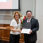 alumna posing with president brien lewis