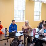 Older lady speaks with students in classroom