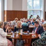 alumni seated at dining table with Brien Lewis