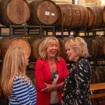 alumni speaking to each other in front of barrels