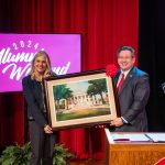 Jennifer A. Moore holding framed art of Old Morrison with Brien Lewis