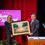 Jennifer A. Moore holding framed art of Old Morrison with Brien Lewis
