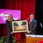Jennifer A. Moore holding framed art of Old Morrison with Brien Lewis
