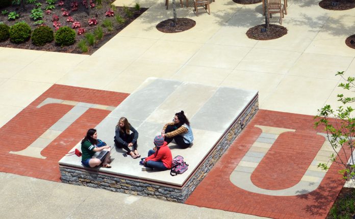 group of 4 students, shot from above, at alumni plaza