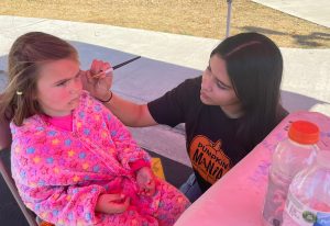 student painting a child's face