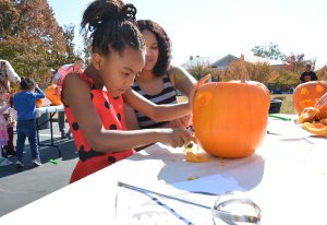 a child carving a pumpkin