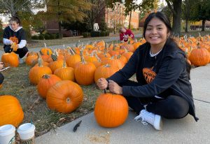student beginning to carve a pumpkin