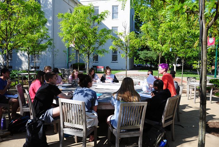 a professor leads a class outdoors in alumni circle