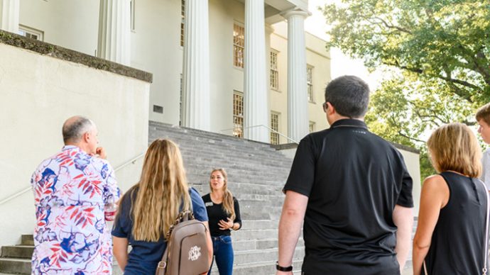 a guide leading a tour in front of old morrison
