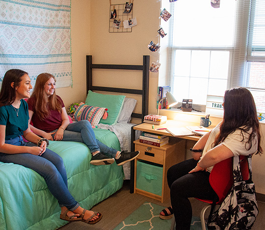 students talking in a residence hall room