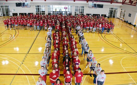 students forming a letter T