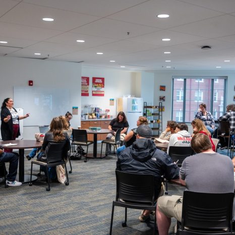 tables and chairs in a large empty room with large windows