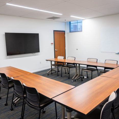 Conference room with tables arranged in horseshoe formation