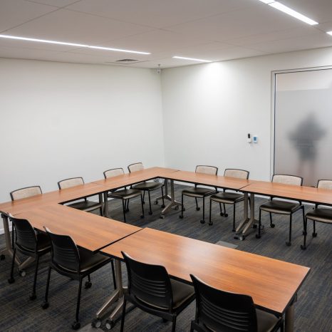 Conference room with tables arranged in horseshoe formation, reverse angle