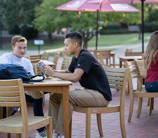 two students studying at tables