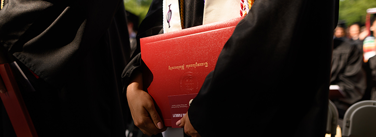 detail photo of graduate holding diploma case
