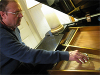 Larry Barnes playing the piano's strings with an ashtray