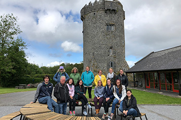 students in front of stone tower
