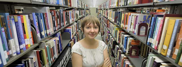 Young Woman between bookshelves