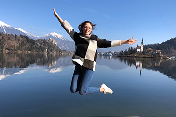 student jumping in front of water