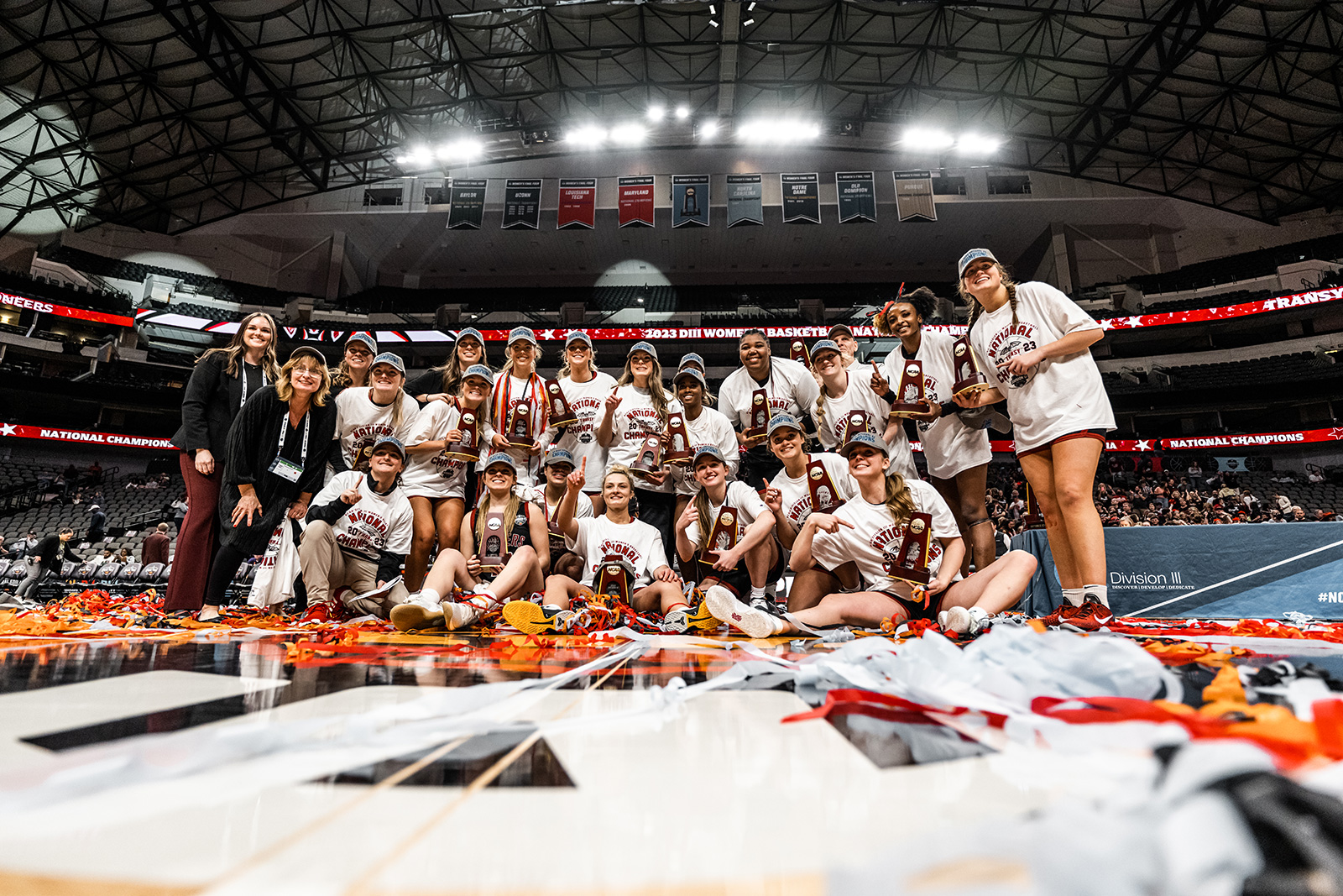 A group shot of the 2022-23 women's basketball team with their individual trophies after the championship win.