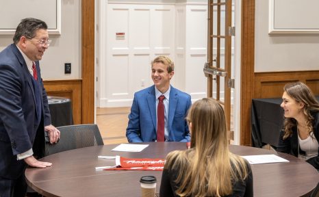 students at a table talking with president Brien Lewis