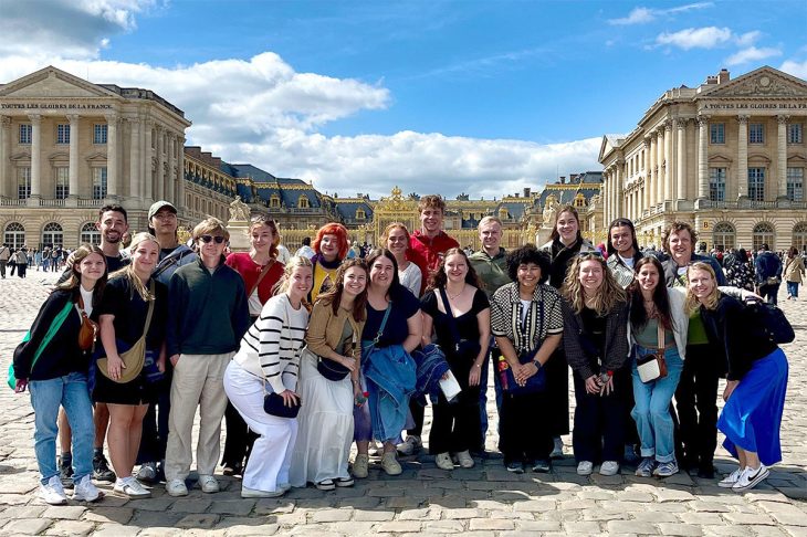 group of students in front of very old buildings
