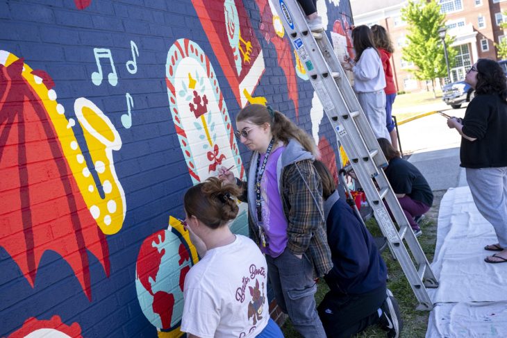multiple students painting a wall