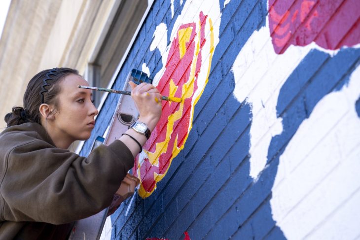 student painting a wall