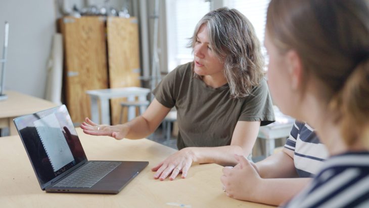 two people looking at a laptop