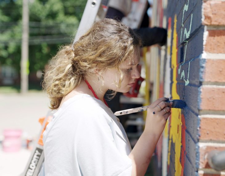 student painting a wall