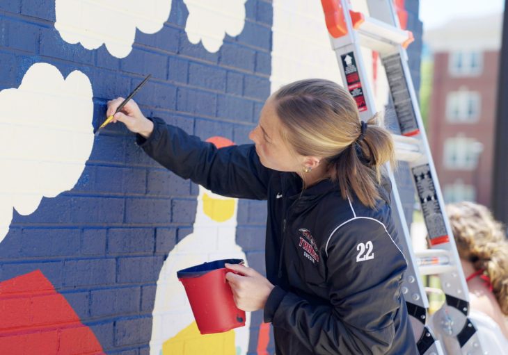student painting a wall