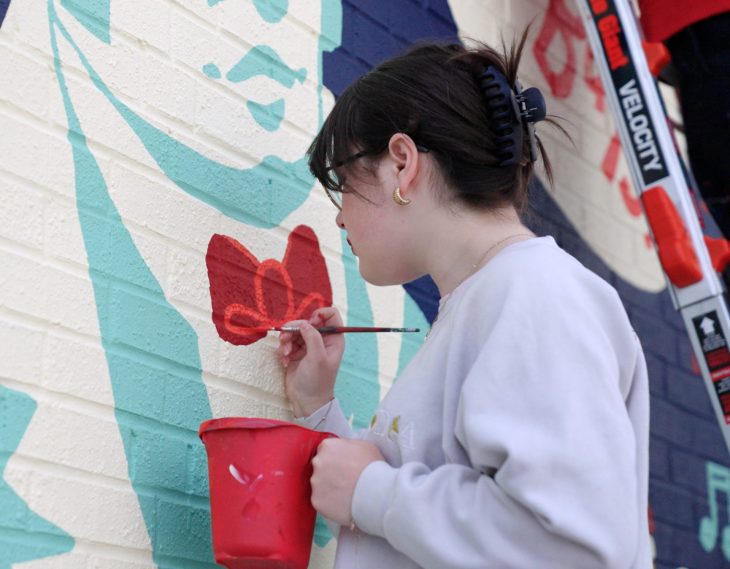 student painting a wall