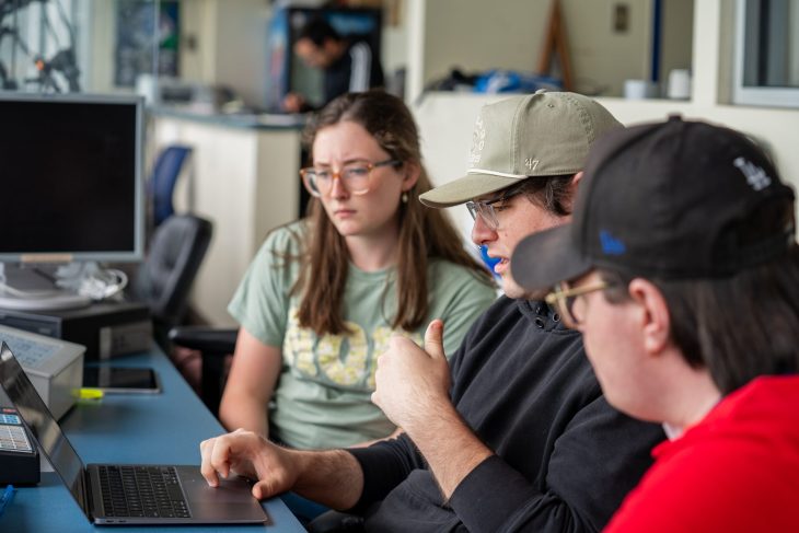students gathered in front of a computer