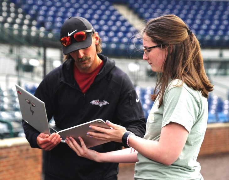 student and coach looking at electronic devices