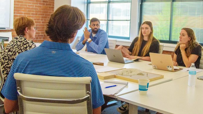 Transylvania University students conversing in a conference room setting