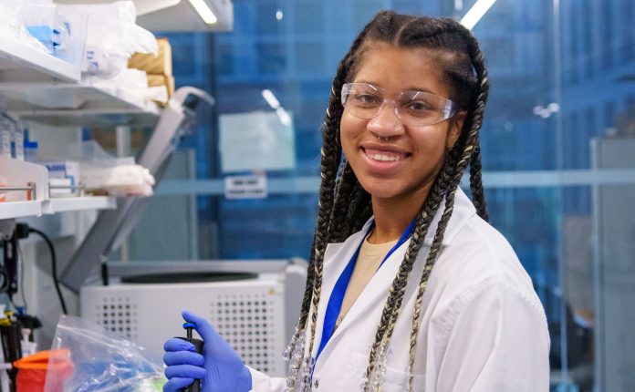 Transylvania University graduate wearing white lab coat and working in a professional laboratory setting.