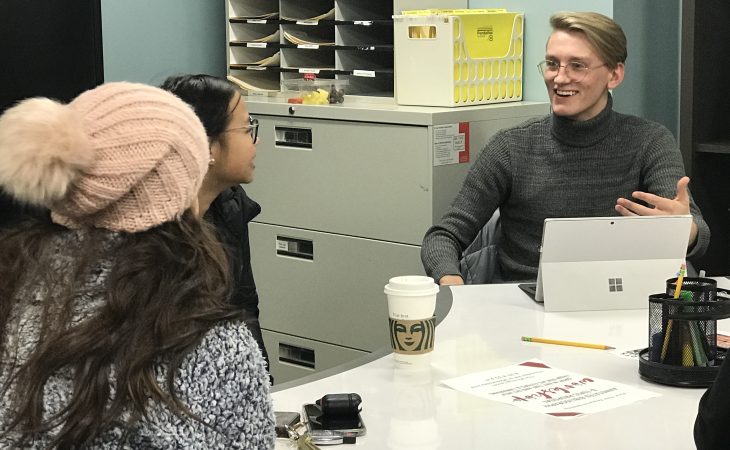 students having a conversation in the writing center